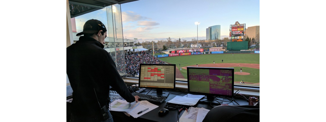 Employee in the control room at Raley Field during a Baseball game