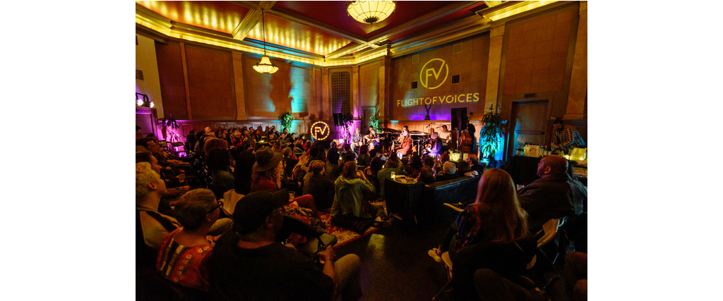 Band playing at FlightofVoices with a full crowd