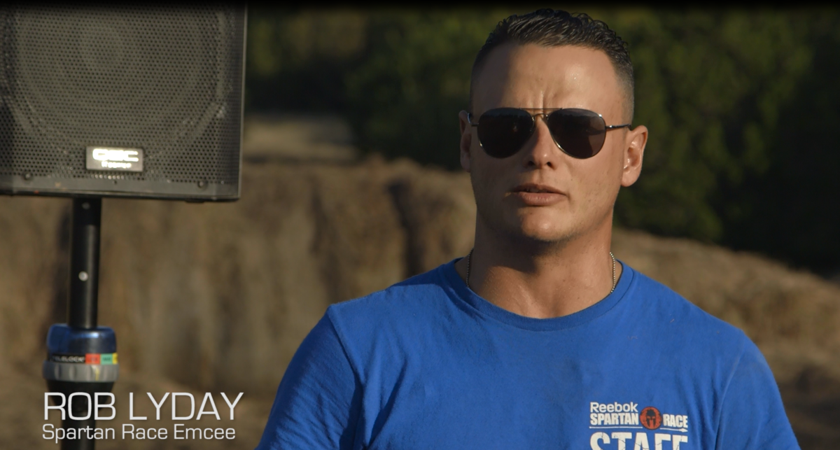 Headshot of Rob Lyday, Spartan Race Emcee with a QSC speaker in the background