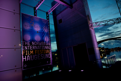A banner for the Norwegian International Film Festival illuminated at night